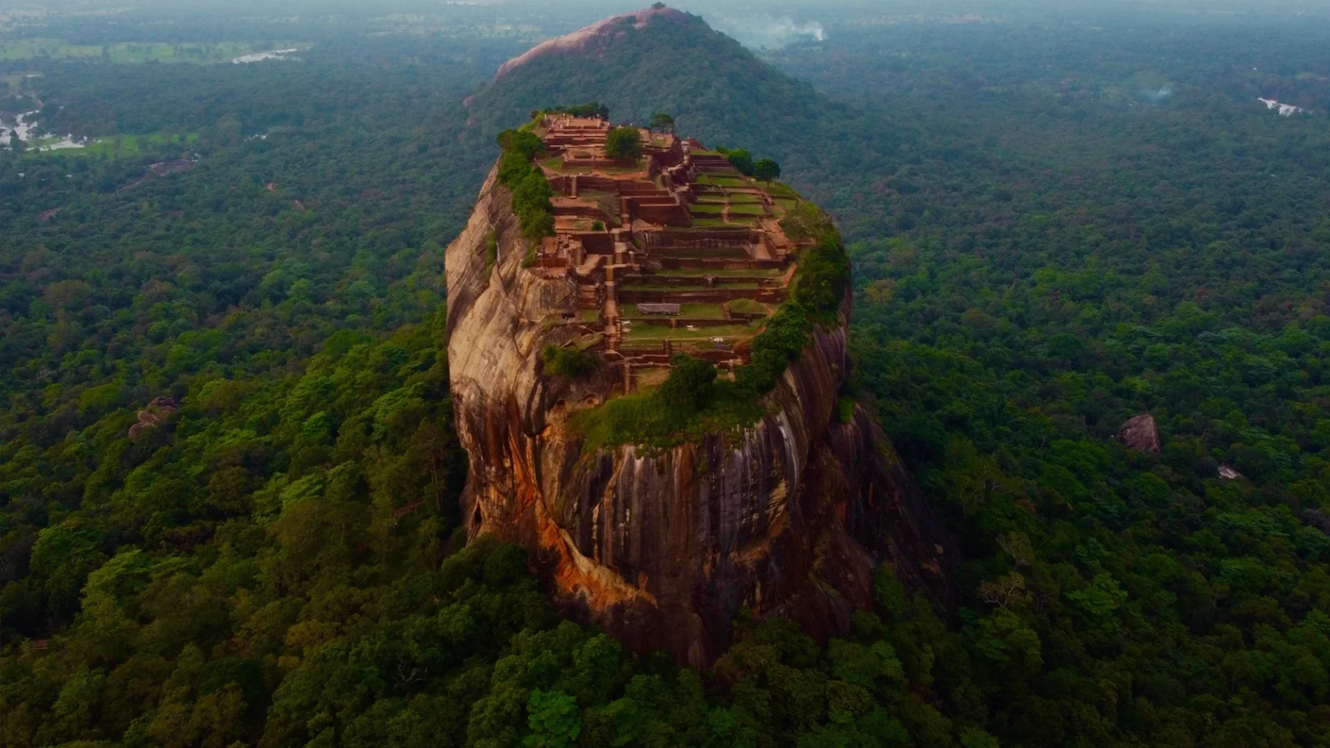 Imagen de una zona de selva en Sri Lanka en la que aparece en el centro una montaña con una zona poblada en su cima plana
